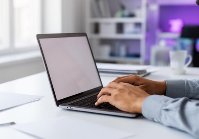 Operations manager reviewing spend controls on a laptop in a bright office with location dashboards open
